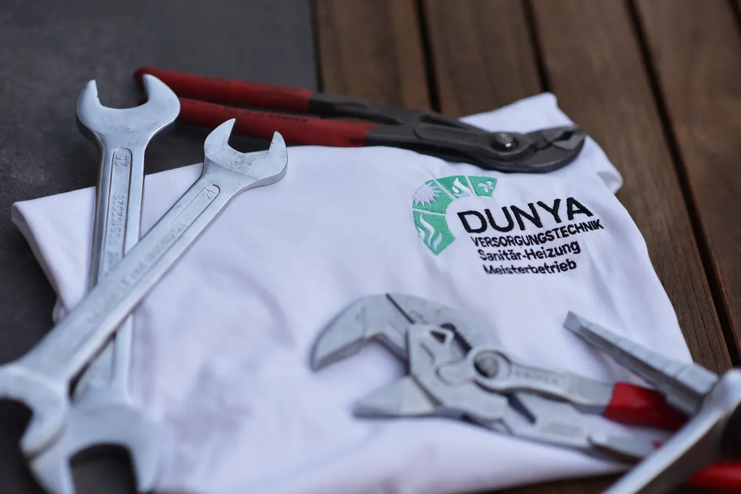Arbeitskleidung mit Dunya-Logo und Werkzeug